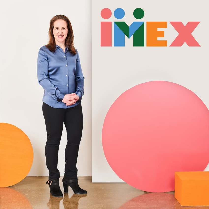 Carina Bauer standing next to the IMEX logo