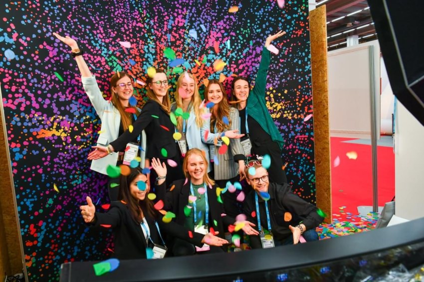 Group of people posing in front of the camera smiling and playing with confetti